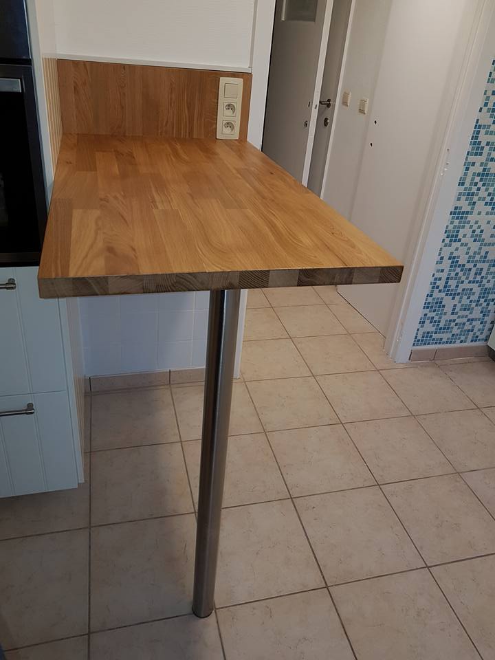 table en bois d'une cuisine avec un seul pied et des prises et un interrupteur